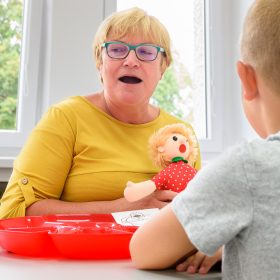Children speech therapy concept. Children practicing correct pronunciation with a female speech therapist. Group therapy banner.