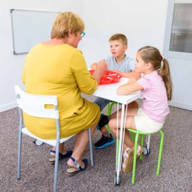 Child occupational therapy session. Group of children doing playful exercises with their therapist.